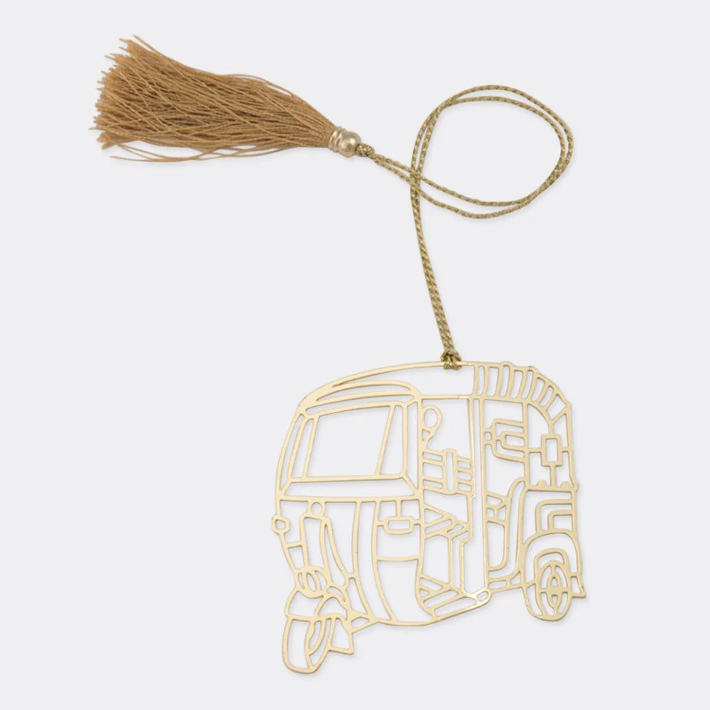 A gold brass bookmark shaped like an Indian auto rickshaw with a tassel.