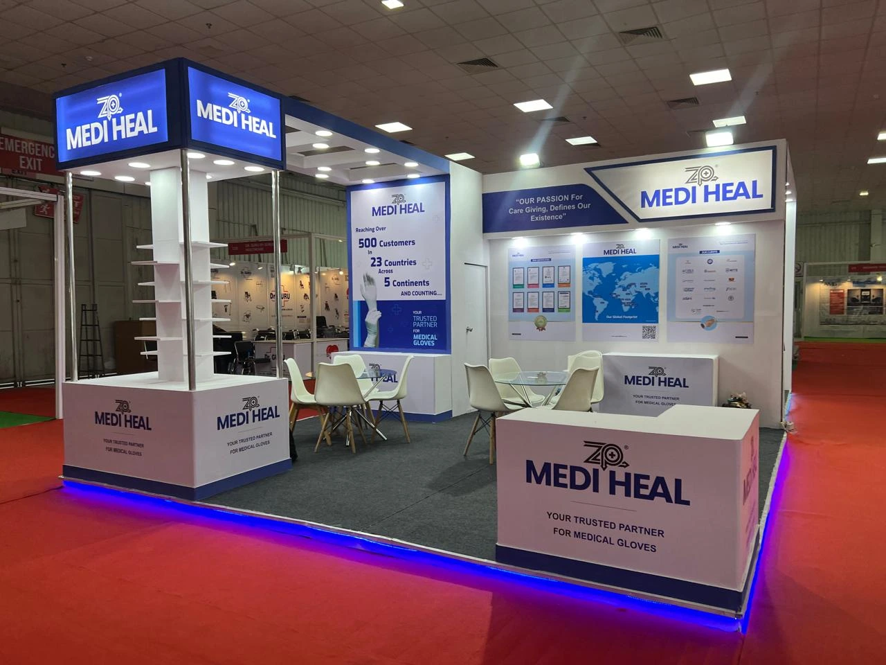 A blue and white Medi Heal exhibition booth with a reception desk and display shelves.